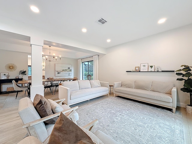 living area featuring an inviting chandelier, recessed lighting, baseboards, wood finished floors, and visible vents