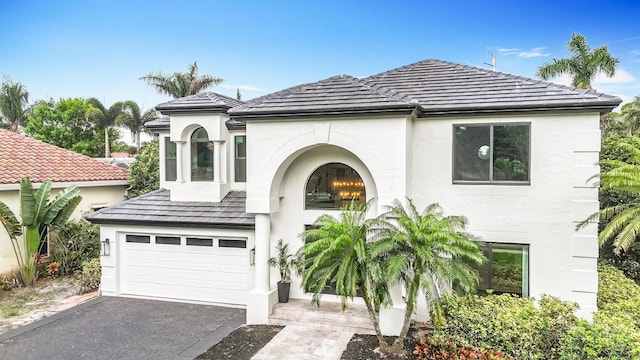 view of front of property with an attached garage, aphalt driveway, and stucco siding