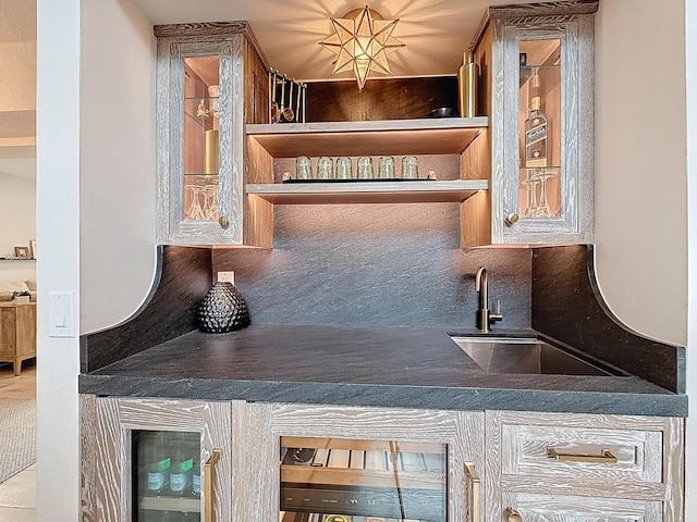 bar with a sink, tasteful backsplash, and indoor wet bar