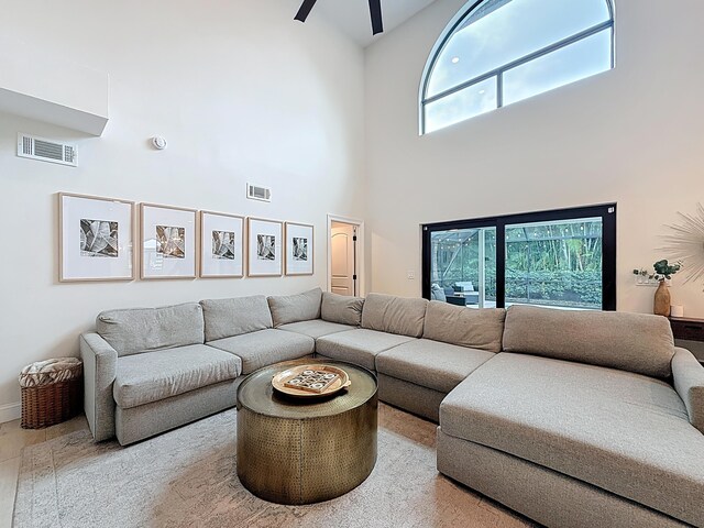 living area featuring visible vents, plenty of natural light, and a towering ceiling