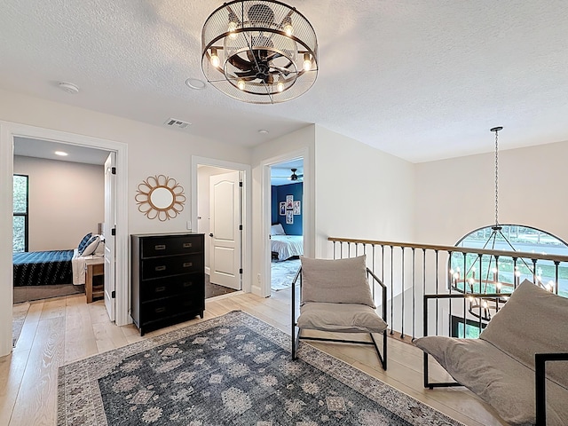 living area featuring an inviting chandelier, plenty of natural light, and light wood-type flooring