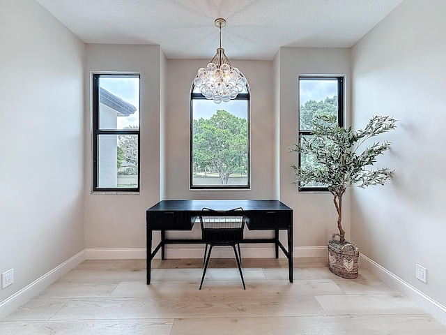 office space with baseboards and an inviting chandelier