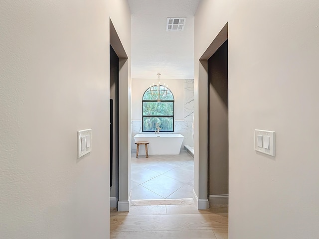 corridor with a chandelier and visible vents