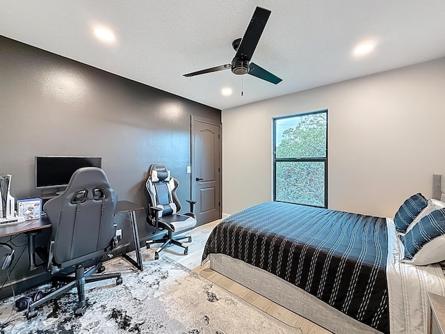 bedroom featuring a textured ceiling, recessed lighting, baseboards, a ceiling fan, and wood finished floors