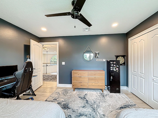 bedroom featuring visible vents, wood finished floors, baseboards, a textured ceiling, and a ceiling fan