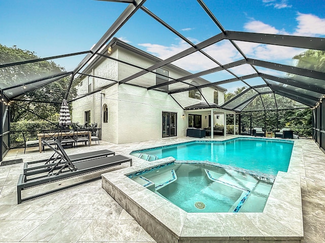 view of swimming pool with a patio, a pool with connected hot tub, a lanai, and an outdoor hangout area