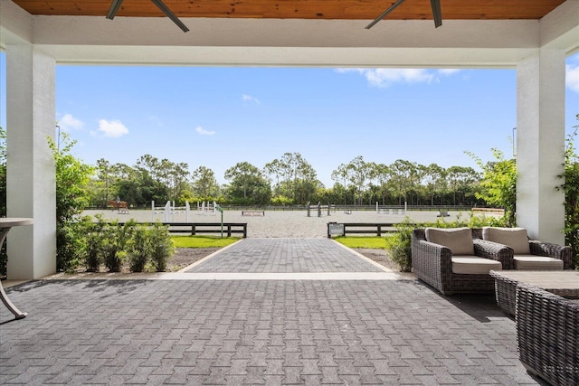 view of patio with an enclosed area, ceiling fan, and fence