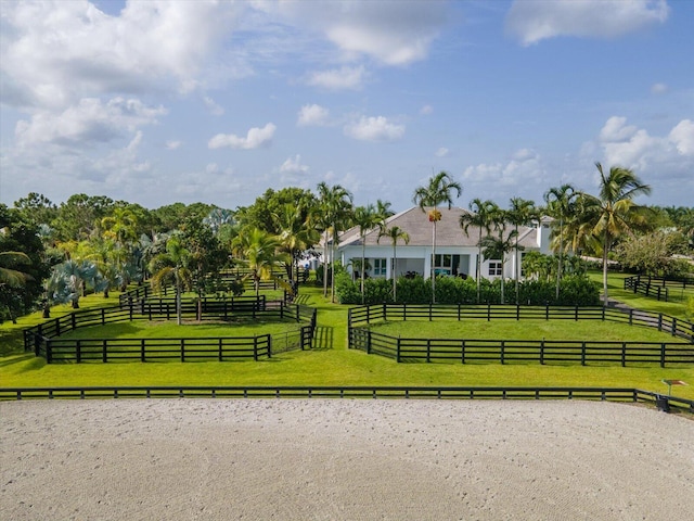 surrounding community featuring a rural view, fence, and a lawn