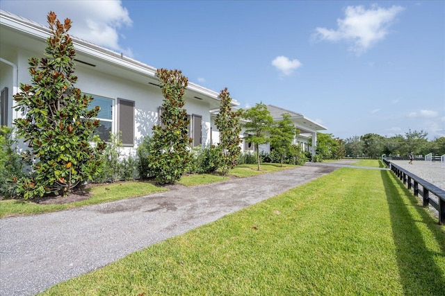 view of home's exterior with a yard, driveway, and stucco siding
