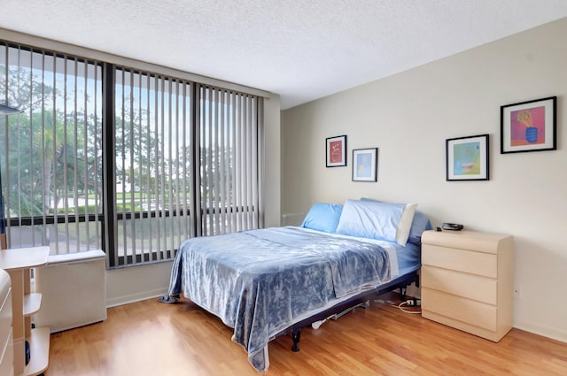 7847 Lakeside Blvd Unit 1023, Boca Raton, FL 33434 - bedroom featuring light wood-style floors, multiple windows, and a textured ceiling