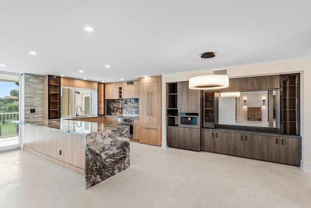 kitchen featuring a sink, oven, modern cabinets, stone counters, and wall oven