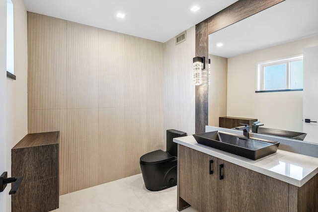 half bathroom with recessed lighting, visible vents, toilet, and vanity