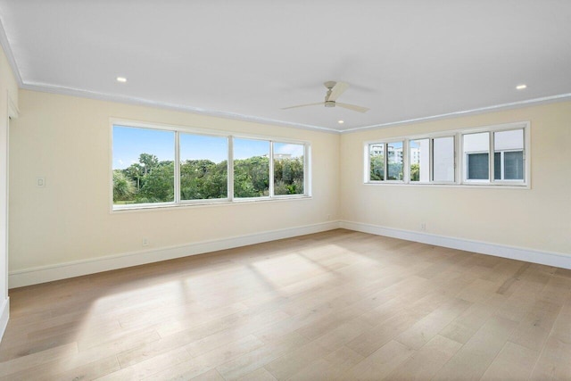 unfurnished room featuring ornamental molding, baseboards, a ceiling fan, and light wood-style floors