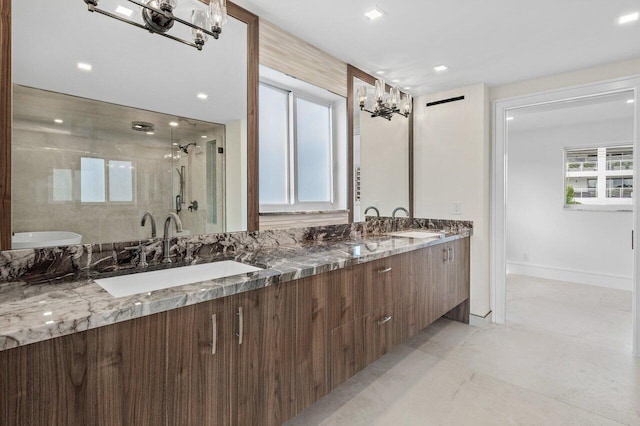 full bath with a shower stall, a sink, a notable chandelier, and double vanity