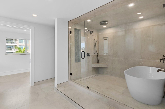 bathroom with a stall shower, marble finish floor, a freestanding bath, baseboards, and recessed lighting