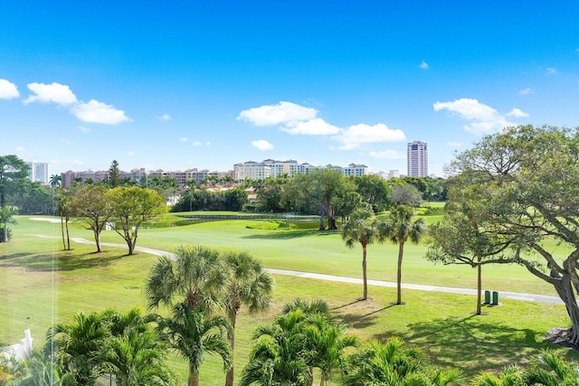 view of property's community featuring a lawn and view of golf course
