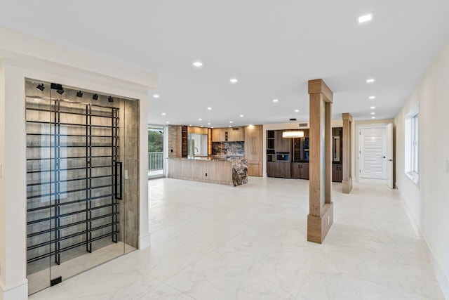 unfurnished living room with recessed lighting, marble finish floor, and a sink