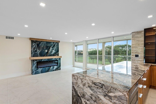 unfurnished living room with a fireplace, visible vents, and recessed lighting