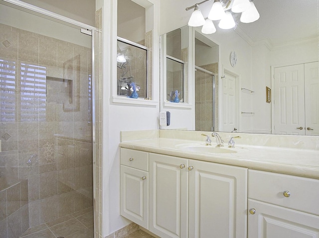 bathroom with a shower stall, crown molding, vanity, and a chandelier