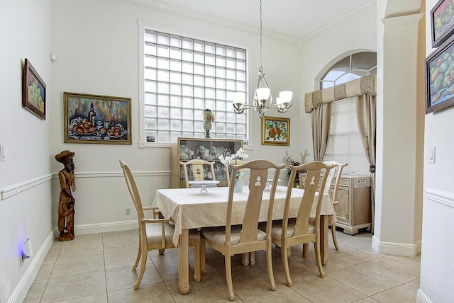 dining room with a chandelier, plenty of natural light, light tile patterned flooring, crown molding, and baseboards