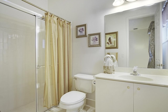 bathroom with a shower stall, toilet, vanity, and tile patterned floors