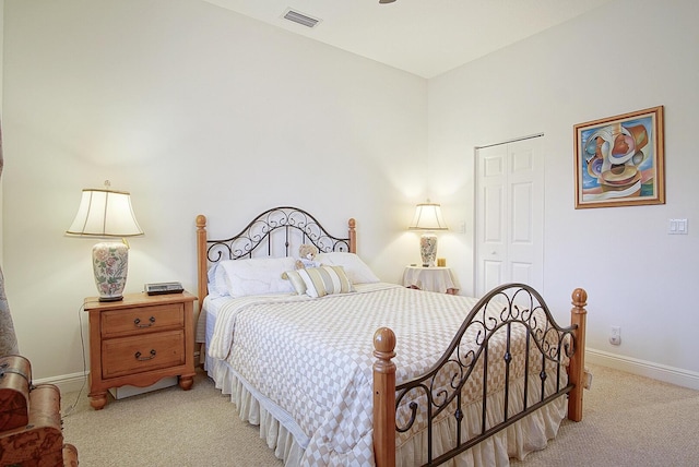 bedroom featuring light carpet, baseboards, and a closet