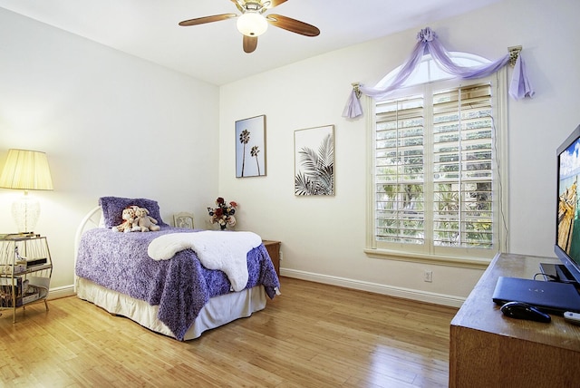 bedroom featuring wood finished floors, baseboards, and ceiling fan