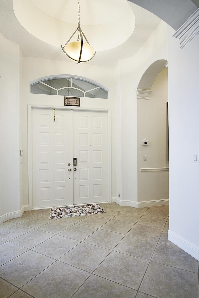 tiled entryway featuring arched walkways and baseboards