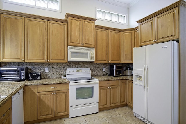 kitchen with white appliances, crown molding, decorative backsplash, light tile patterned floors, and brown cabinets