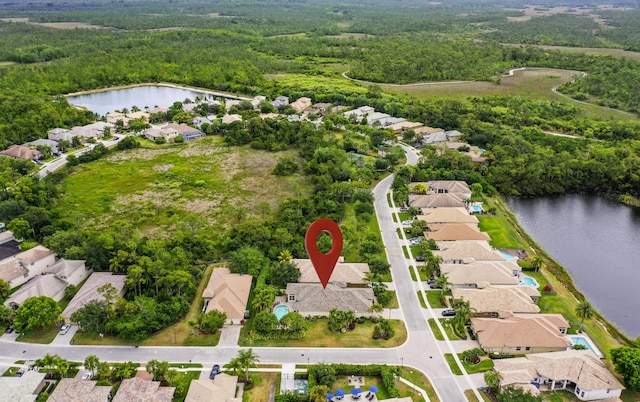 aerial view of property's location with a heavily wooded area, a large body of water, and nearby suburban area