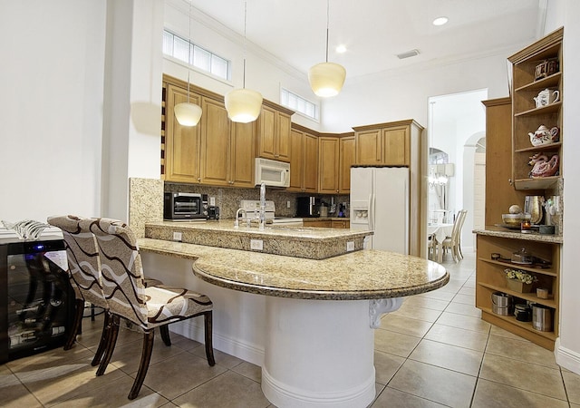 kitchen with open shelves, white appliances, a peninsula, a kitchen breakfast bar, and arched walkways