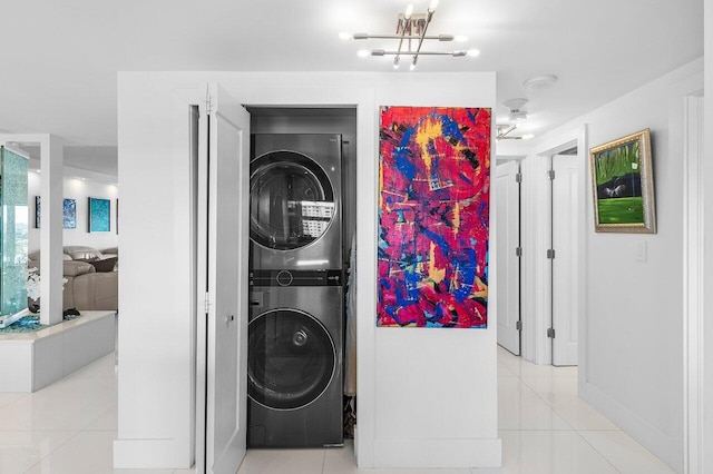 400 Seasage Dr Unit 804, Delray Beach, FL 33483 - washroom featuring stacked washer and dryer, tile patterned flooring, laundry area, and an inviting chandelier