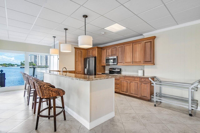 400 Seasage Dr Unit 804, Delray Beach, FL 33483 - kitchen with stainless steel appliances, a kitchen bar, stone countertops, brown cabinetry, and ornamental molding