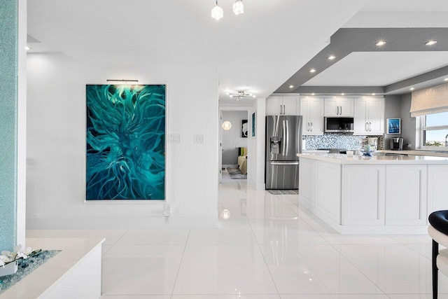 400 Seasage Dr Unit 804, Delray Beach, FL 33483 - kitchen with stainless steel appliances, light countertops, light tile patterned floors, tasteful backsplash, and white cabinetry
