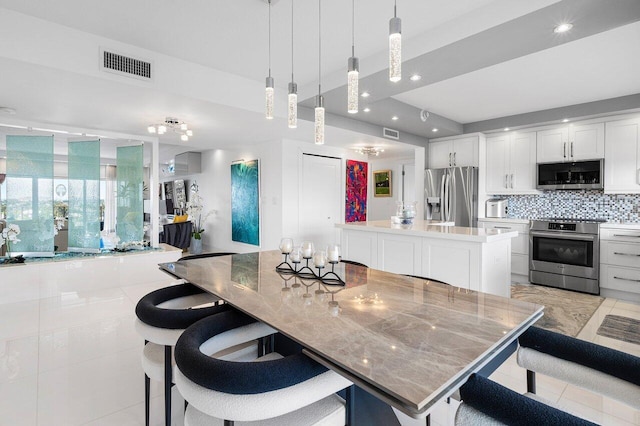 400 Seasage Dr Unit 804, Delray Beach, FL 33483 - kitchen with a spacious island, tasteful backsplash, visible vents, and stainless steel appliances