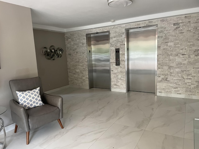 living area with elevator, baseboards, and marble finish floor