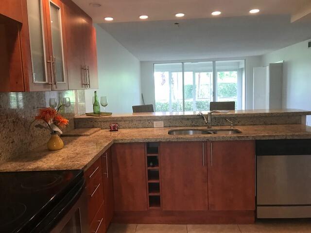 kitchen featuring glass insert cabinets, electric range oven, a sink, stainless steel dishwasher, and light stone counters