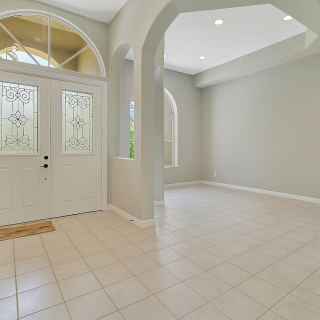 21504 Halstead Dr, Boca Raton, FL 33428 - foyer with arched walkways, baseboards, light tile patterned floors, and recessed lighting