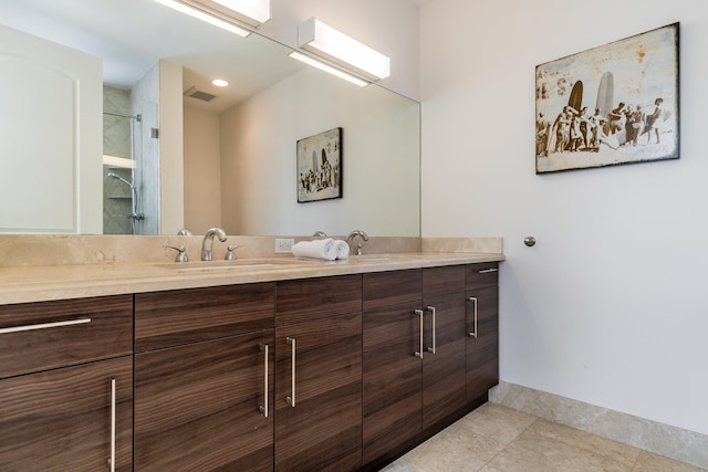 full bathroom with a sink, an enclosed shower, double vanity, visible vents, and baseboards