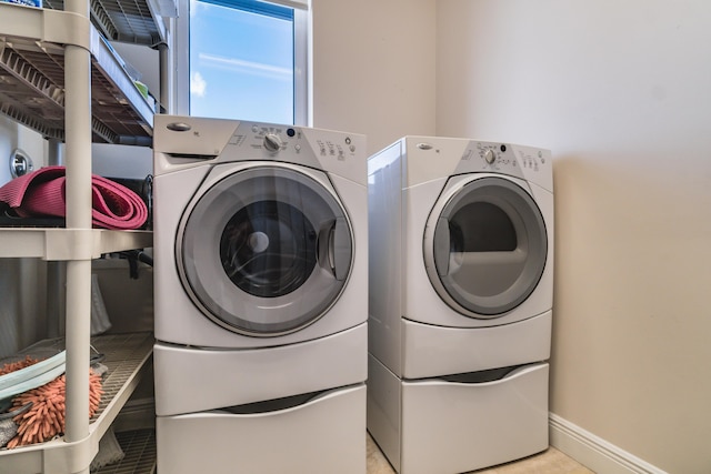laundry room featuring washing machine and dryer, laundry area, and baseboards