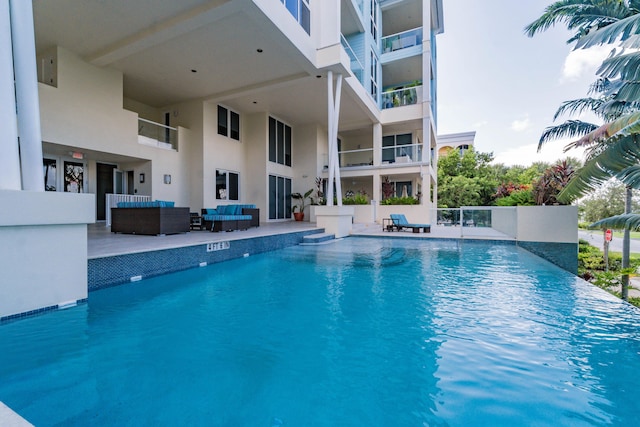 outdoor pool with a patio and an outdoor living space