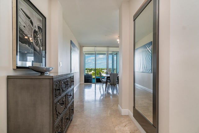 corridor featuring a wall of windows and baseboards