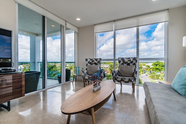 living room with tile patterned floors, a wall of windows, and a healthy amount of sunlight