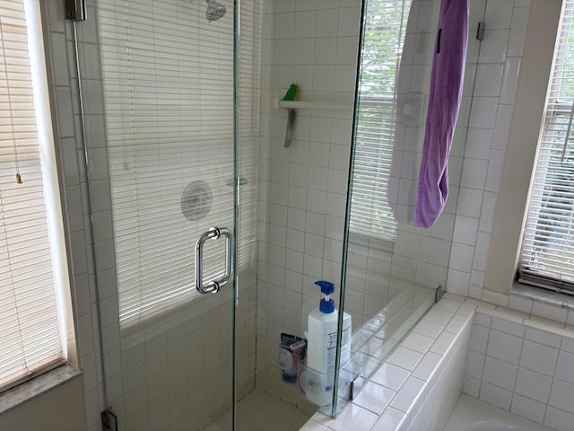bathroom with a shower stall and a bath