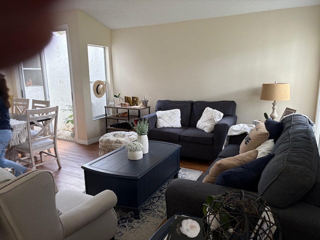 living area with baseboards and wood finished floors