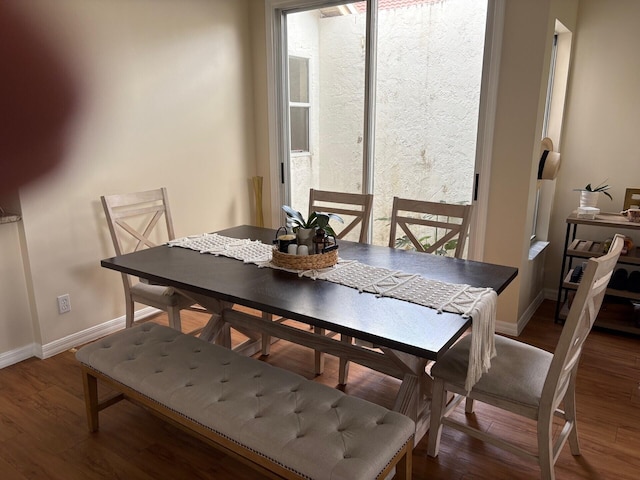 dining area featuring baseboards and wood finished floors