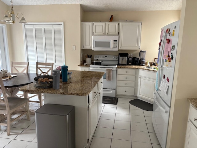 kitchen featuring white cabinets, a notable chandelier, white appliances, and light tile patterned floors