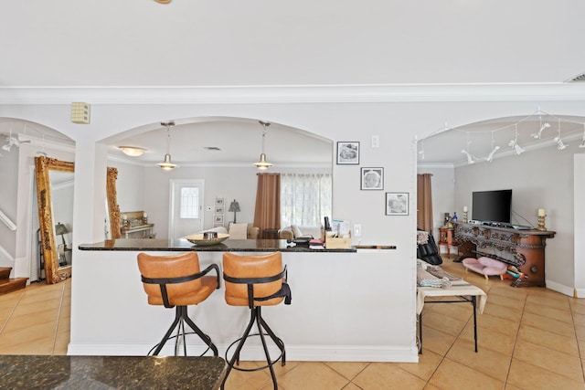 442 SE 17th Ter, Deerfield Beach, FL 33441 - kitchen featuring arched walkways, a breakfast bar, crown molding, and light tile patterned flooring
