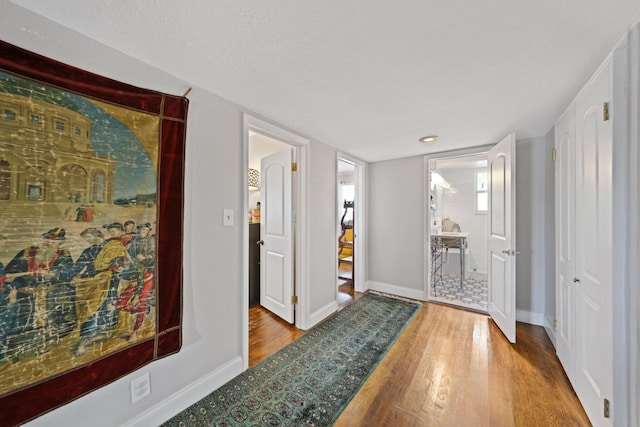 442 SE 17th Ter, Deerfield Beach, FL 33441 - corridor with a textured ceiling, wood finished floors, and baseboards