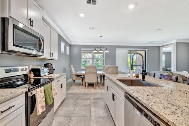 6449 NW Castlebrook Ave, Port Saint Lucie, FL 34983 - kitchen with appliances with stainless steel finishes, a sink, visible vents, and light stone counters